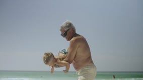 Le grand-papa et son petit-fils ont l'amusement sur la plage 4k clips vidéos Le grand-papa et son petit-fils ont l'amusement sur la plage 4k clips vidéos