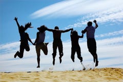 Le groupe d'amis saute sur le sable, vue arrière image libre de droits Le groupe d'amis saute sur le sable, vue arrière image libre de droits