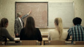 Le groupe d'étudiants dans une salle de classe, écoutant en tant que leur professeur tient une conférence banque de vidéos Le groupe d'étudiants dans une salle de classe, écoutant en tant que leur professeur tient une conférence banque de vidéos