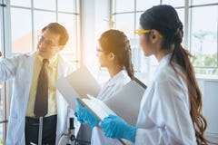 Le groupe d'étudiants en médecine asiatiques recherchent le nouveau projet avec le professeur supérieur au laboratoire photos libres de droits Le groupe d'étudiants en médecine asiatiques recherchent le nouveau projet avec le professeur supérieur au laboratoire photos libres de droits