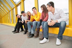 Le groupe de jeunes s'asseyent sur la passerelle images libres de droits Le groupe de jeunes s'asseyent sur la passerelle images libres de droits