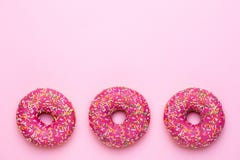 Le guarnizioni di gomma piuma rosa dolci con multicolore spruzza su un fondo rosa piano si situano immagini stock libere da diritti Le guarnizioni di gomma piuma rosa dolci con multicolore spruzza su un fondo rosa piano si situano immagini stock libere da diritti