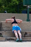 Le jeune femme fait des pousées contre des pas concrets Photos stock Le jeune femme fait des pousées contre des pas concrets Photos stock