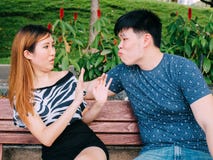 Le jeune homme asiatique essayant d'embrasser une fille et obtient rejeté Images stock Le jeune homme asiatique essayant d'embrasser une fille et obtient rejeté Images stock