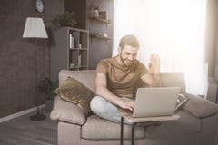 Le jeune homme barbu a la conversation en ligne à la maison photos libres de droits Le jeune homme barbu a la conversation en ligne à la maison photos libres de droits