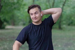 Le jeune homme caucasien bel met une main sur le cou, expression compliquée sur le visage, souriant images libres de droits Le jeune homme caucasien bel met une main sur le cou, expression compliquée sur le visage, souriant images libres de droits