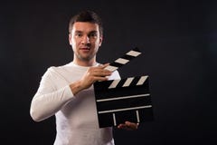 Le jeune homme de l'aspect caucasien tient une claquette Por photo libre de droits Le jeune homme de l'aspect caucasien tient une claquette Por photo libre de droits