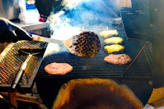 Le jeune homme grille un certain genre de viande et de légume marinés sur le gril de gaz pendant l'heure d'été photos stock Le jeune homme grille un certain genre de viande et de légume marinés sur le gril de gaz pendant l'heure d'été photos stock