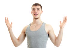 Le jeune type étonné a soulevé ses mains, recherchant et souriant image stock Le jeune type étonné a soulevé ses mains, recherchant et souriant image stock