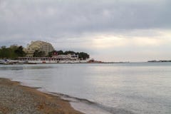 Le littoral de la baie de Gelendzhik Remblai vert, bâtiments côtiers, montagnes, mer verte, ciel gris avec les nuages gris image libre de droits Le littoral de la baie de Gelendzhik Remblai vert, bâtiments côtiers, montagnes, mer verte, ciel gris avec les nuages gris image libre de droits