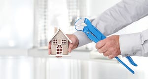 Le mani con la casa e la chiave stringitubo, casa della costruzione ed installano immagini stock libere da diritti Le mani con la casa e la chiave stringitubo, casa della costruzione ed installano immagini stock libere da diritti