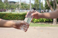 Le mani degli uomini è di dare una bottiglia immagini stock Le mani degli uomini è di dare una bottiglia immagini stock