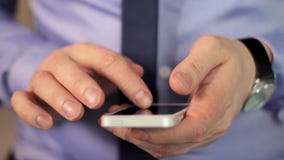 Le mani dell'uomo del primo piano facendo uso dello schermo attivabile al tatto del telefono cellulare video d archivio Le mani dell'uomo del primo piano facendo uso dello schermo attivabile al tatto del telefono cellulare video d archivio