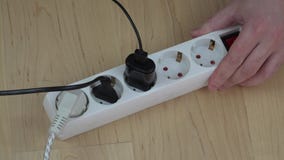 Le mani dell'uomo spengono il commutatore di estensione dell'elettricità e disinseriscono i cavi Le mani dell'uomo spengono il commutatore di estensione dell'elettricità e disinseriscono i cavi