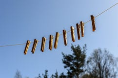 Le mollette da bucato per i vestiti ed i vestiti appendono contro il cielo blu un giorno soleggiato su uno stretto fotografia stock Le mollette da bucato per i vestiti ed i vestiti appendono contro il cielo blu un giorno soleggiato su uno stretto fotografia stock