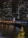 Le paysage urbain de Chicago a illuminé des lumières de nuit sur les bâtiments et la rivière réfléchis Images libres de droits Le paysage urbain de Chicago a illuminé des lumières de nuit sur les bâtiments et la rivière réfléchis Images libres de droits