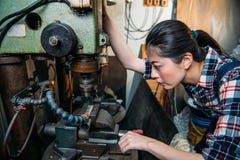 Le personnel féminin d'usine ajustent les machines industrielles photos libres de droits Le personnel féminin d'usine ajustent les machines industrielles photos libres de droits