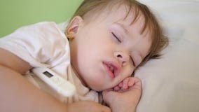 Le petit enfant dort dans la salle d'hôpital sur la température blanche de literie et de mesures avec le thermomètre Traitement d clips vidéos Le petit enfant dort dans la salle d'hôpital sur la température blanche de literie et de mesures avec le thermomètre Traitement d clips vidéos