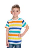 Le petit garçon blond se tient contre le blanc images stock Le petit garçon blond se tient contre le blanc images stock