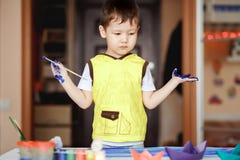 Le petit garçon dans un T-shirt jaune a souillé avec la peinture photos libres de droits Le petit garçon dans un T-shirt jaune a souillé avec la peinture photos libres de droits