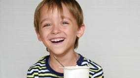 Le petit garçon rit de la caméra L'enfant s'assied à la table et mange du yaourt ?motions heureuses blanc cru de macaronis de nou banque de vidéos Le petit garçon rit de la caméra L'enfant s'assied à la table et mange du yaourt ?motions heureuses blanc cru de macaronis de nou banque de vidéos
