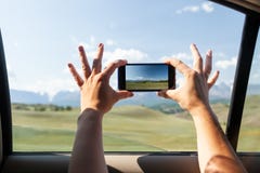 Le plan rapproché d'un jeune touriste dans la voiture fait une photo image stock Le plan rapproché d'un jeune touriste dans la voiture fait une photo image stock