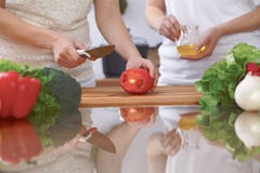Le plan rapproché de quatre mains humaines font cuire dans une cuisine Amis ayant l'amusement tout en préparant la salade fraîche Photographie stock libre de droits