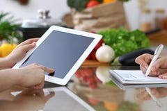 Le plan rapproché des mains humaines sont gesticulent au-dessus d'un comprimé dans la cuisine Amis ayant l'amusement tout en choi images libres de droits Le plan rapproché des mains humaines sont gesticulent au-dessus d'un comprimé dans la cuisine Amis ayant l'amusement tout en choi images libres de droits