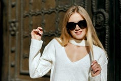 Le plan rapproché tiré de la fille blonde fraîche avec le long port de cheveux tricotent le whi image stock Le plan rapproché tiré de la fille blonde fraîche avec le long port de cheveux tricotent le whi image stock