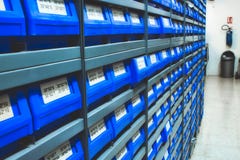 Le plastique bleu dessine de courant/de parties dans les rangées des étagères photos stock Le plastique bleu dessine de courant/de parties dans les rangées des étagères photos stock