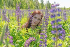 Le portrait d'une belle femme avec les yeux verts brunissent de longs cheveux sur un champ des fleurs image libre de droits Le portrait d'une belle femme avec les yeux verts brunissent de longs cheveux sur un champ des fleurs image libre de droits