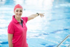 Le portrait de l'entraîneur féminin avec un chronomètre et le presse-papiers par la piscine aux loisirs centrent images libres de droits Le portrait de l'entraîneur féminin avec un chronomètre et le presse-papiers par la piscine aux loisirs centrent images libres de droits