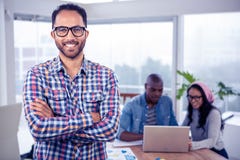Le portrait de l'homme d'affaires heureux se tenant avec des bras a croisé dans le bureau image libre de droits Le portrait de l'homme d'affaires heureux se tenant avec des bras a croisé dans le bureau image libre de droits