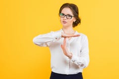 Le portrait de la belle jeune femme élégante sérieuse sûre d'affaires montrant la temporisation se connectent le fond jaune Images libres de droits Le portrait de la belle jeune femme élégante sérieuse sûre d'affaires montrant la temporisation se connectent le fond jaune Images libres de droits