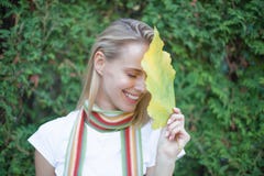 Le portrait de luxe d'une belle jeune femme avec le maquillage naturel tient une grande feuille verte sur un fond vert brouillé S photo stock Le portrait de luxe d'une belle jeune femme avec le maquillage naturel tient une grande feuille verte sur un fond vert brouillé S photo stock