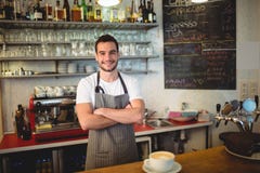 Le portrait du barman sûr avec des bras a croisé au café Photo libre de droits Le portrait du barman sûr avec des bras a croisé au café Photo libre de droits