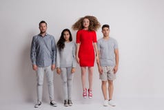 Le portrait du jeune groupe d'amis se tenant dans un studio, un saute images stock Le portrait du jeune groupe d'amis se tenant dans un studio, un saute images stock