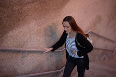 Le portrait en buste de la vue supérieure d'une jeune fille sur les escaliers du souterrain, la transition se tient dessus sur un photographie stock Le portrait en buste de la vue supérieure d'une jeune fille sur les escaliers du souterrain, la transition se tient dessus sur un photographie stock