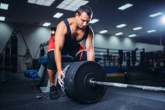 Le powerlifter masculin prépare un barbell dans le gymnase image stock Le powerlifter masculin prépare un barbell dans le gymnase image stock