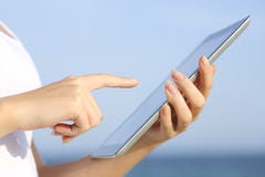 Le profil d'une femme remet tenir et passer en revue un comprimé numérique sur la plage photos libres de droits Le profil d'une femme remet tenir et passer en revue un comprimé numérique sur la plage photos libres de droits