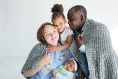Le père aimant couvre sa famille de plaid Famille multi-ethnique heureuse Valeurs familiales image stock Le père aimant couvre sa famille de plaid Famille multi-ethnique heureuse Valeurs familiales image stock