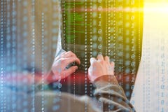 Le regard de programmeur de pirates informatiques sur l'écran et écrit l'information et le compte utilisateur d'entaille de code photographie stock libre de droits Le regard de programmeur de pirates informatiques sur l'écran et écrit l'information et le compte utilisateur d'entaille de code photographie stock libre de droits