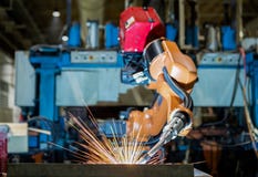 Le robot industriel soude la partie dans l'usine industrielle des véhicules à moteur image libre de droits Le robot industriel soude la partie dans l'usine industrielle des véhicules à moteur image libre de droits