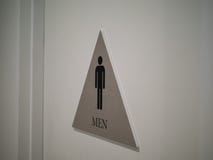 Le signe de toilettes de Men’s a apposé à la porte dans l'immeuble de bureaux à l'intérieur photo libre de droits Le signe de toilettes de Men’s a apposé à la porte dans l'immeuble de bureaux à l'intérieur photo libre de droits