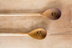 Le smiley en bois fait face à des cuillères sur le fond en bois photos stock Le smiley en bois fait face à des cuillères sur le fond en bois photos stock