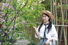 Le sourire chinois d'étudiante de lycée de l'Asie de belle beauté apprécient le jeu de temps gratuit dans le bambou de jardin de image stock Le sourire chinois d'étudiante de lycée de l'Asie de belle beauté apprécient le jeu de temps gratuit dans le bambou de jardin de image stock