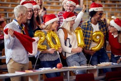 Le studenter i jultomtenhatten som rymmer 2019 guld- ballonger på partiet för nytt år royaltyfri bild Le studenter i jultomtenhatten som rymmer 2019 guld- ballonger på partiet för nytt år royaltyfri bild