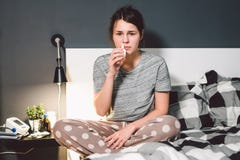 Le thème est froid saisonnier, infection de virus de grippe d'écoulement nasal Le jeune lit caucasien de chambre à coucher de fem photo libre de droits Le thème est froid saisonnier, infection de virus de grippe d'écoulement nasal Le jeune lit caucasien de chambre à coucher de fem photo libre de droits