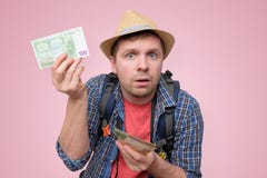 Le touriste dans le chapeau tient l'euro billet de banque le vérifiant photo libre de droits Le touriste dans le chapeau tient l'euro billet de banque le vérifiant photo libre de droits