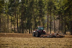 Le tracteur laboure le champ Ressort, le d?but de la saison de plantation Grands tours de tracteur sur le champ images stock Le tracteur laboure le champ Ressort, le d?but de la saison de plantation Grands tours de tracteur sur le champ images stock